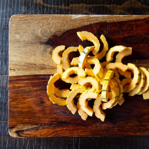 Delicata squash sliced into half circles.