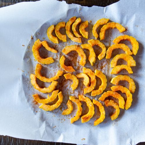 Sliced delicata squash sprinkled with spices.