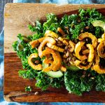 Finished Spicy Delicata Squash Salad with massaged kale, avocado slices, and roasted pumpkin seeds.