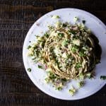 An artichoke on a plate stuffed with tabbouleh that's made with quinoa instead of bulgar.