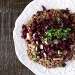 A white platter of lentils topped with a pickled beet salad, parsley and preserved lemon.