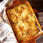 Baking dish of a potato gratin with poblano peppers, topped with breadcrumbs.