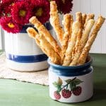 Puff pastry cheese straws in a ceramic bowl.