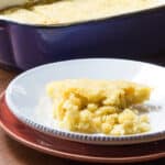 A plate of tomalito sweet cornbread, with the casserole in the background.