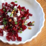 A dish of quick pickled beets tossed with goat cheese, chives and pepitas.