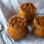 Three small jars of sun dried tomato pesto.