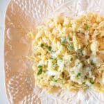 A serving platter heaped with cauliflower scampi with pasta.