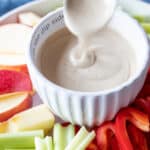 Maple tahini Sauce poured into a dipping cup with veggies.