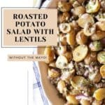 A bowl filled with roasted potato salad with lentils with text overlay.