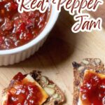 A ramekin of red pepper jam with some crackers and cheese.