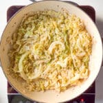 A braiser of freshly cooked French Braised Cabbage on top of an induction stovetop.